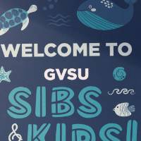 A foam sign with sea animals and text that reads "Welcome to GVSU Sibs & Kids!"